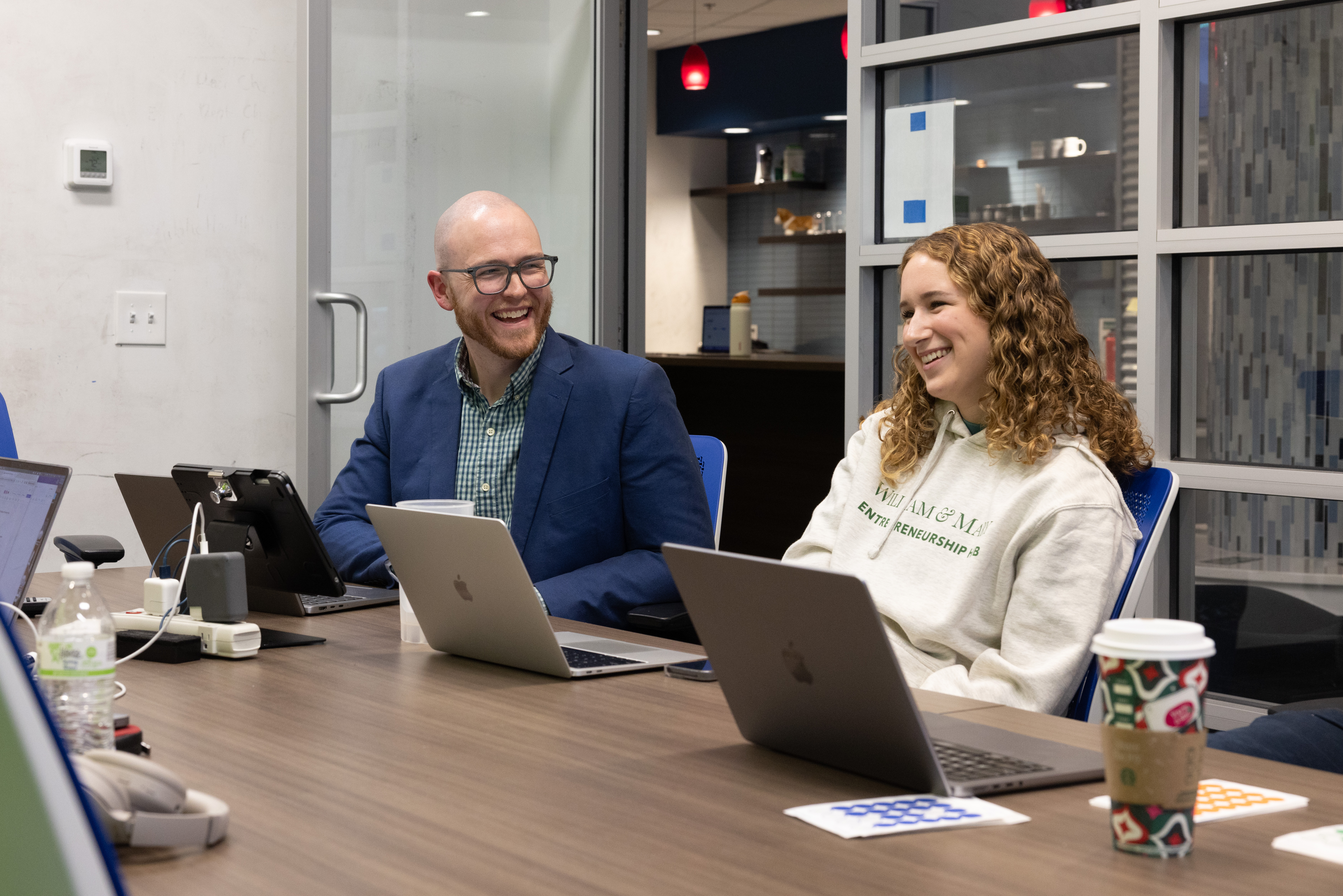 A student and professor smile in a conference room